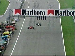 The chequered flag. Irvine wins with Coulthard on his tail