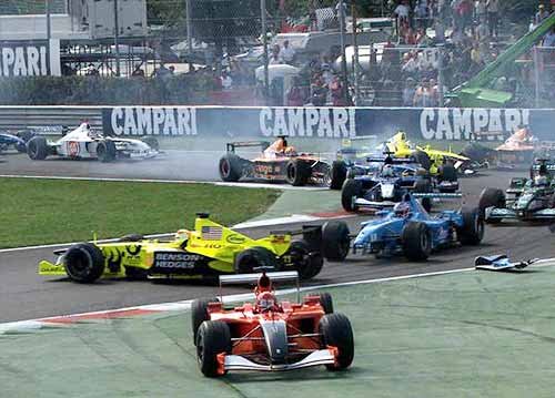 The start. Button sends Trulli spinning and all the other cars must cut the chicane to avoid the accident