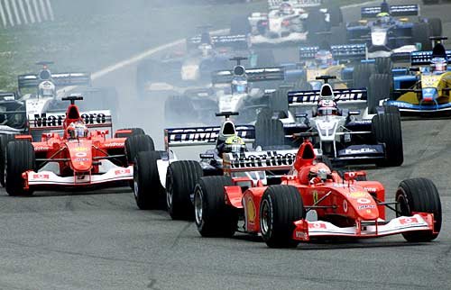 The start. R. Schumacher squeezes between M. Schumacher and Barrichello.